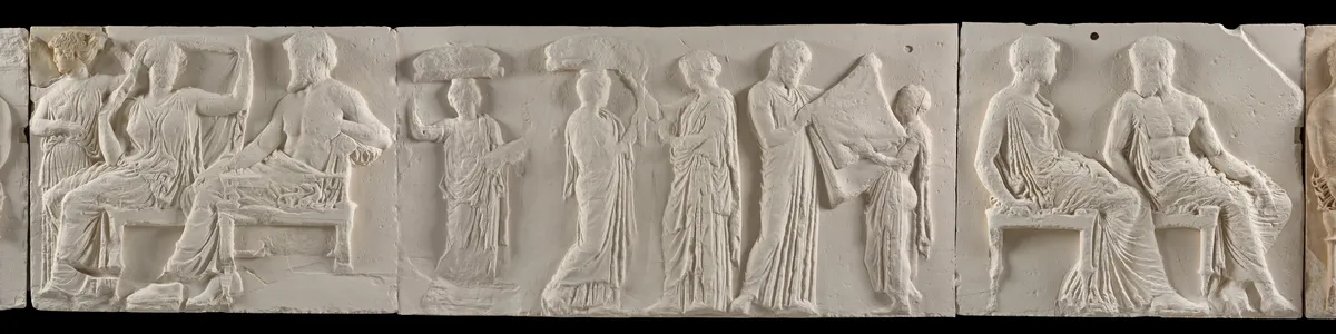 white stone wall carvings of people in ancient Greece