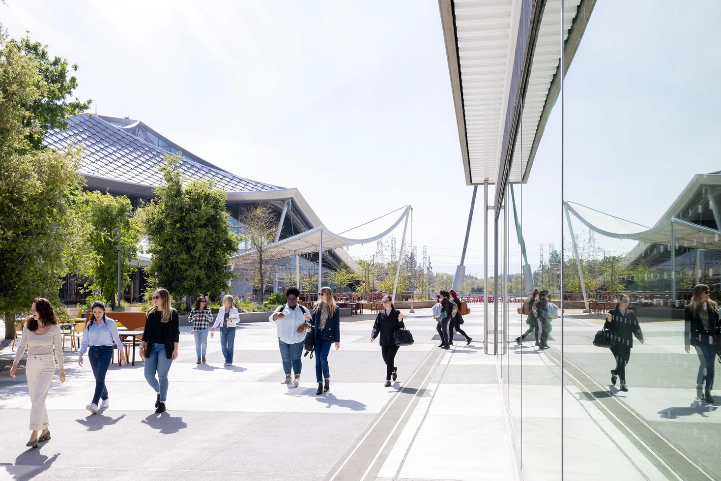 Employees walk through an outdoor courtyard between two office buildings.