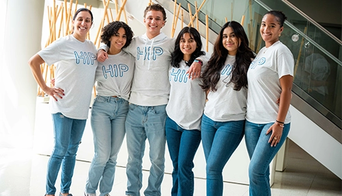 Group of young adults smiling and looking at the camera