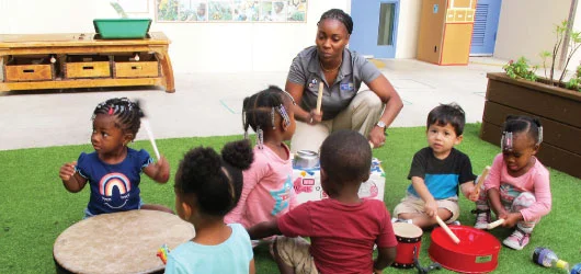 Adult and young children playing in a room