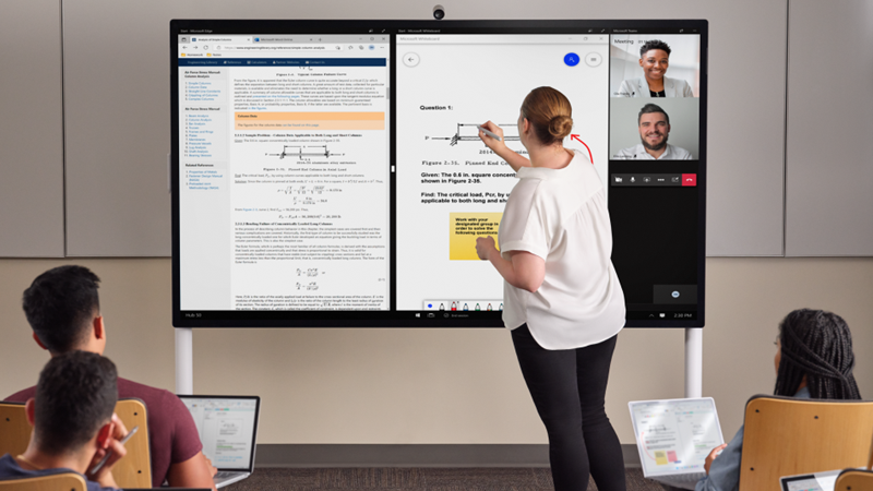 Een docent staat aan de voorkant van een klas met inkt op een Hub 85 inch met een lichtgrijs Surface-pen. Edge Whiteboard en Teams bevinden zich op het scherm. Op de voorgrond hebben verschillende studenten een Pro 7+ en maken ze notities in One Note.