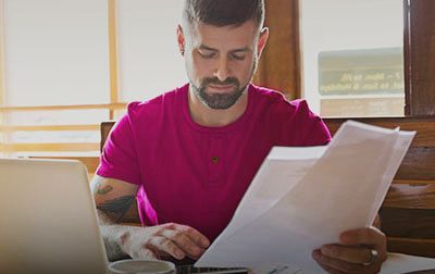 Man looking at papers and a computer