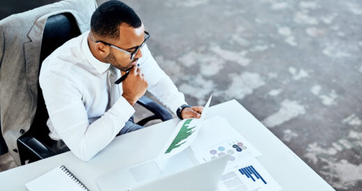 Cropped shot of a handsome young businessman sitting in his office and looking contemplative while reading paperwork