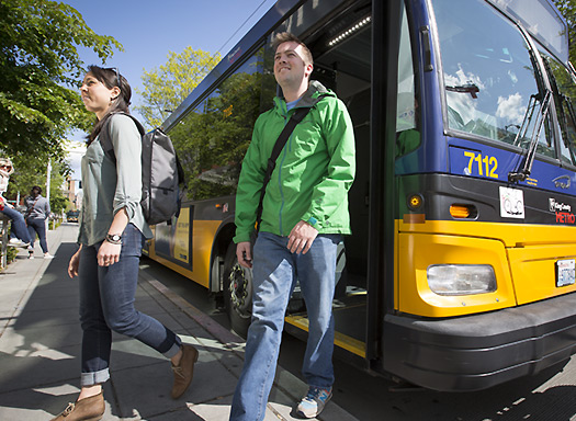 People exiting a bus on campus.