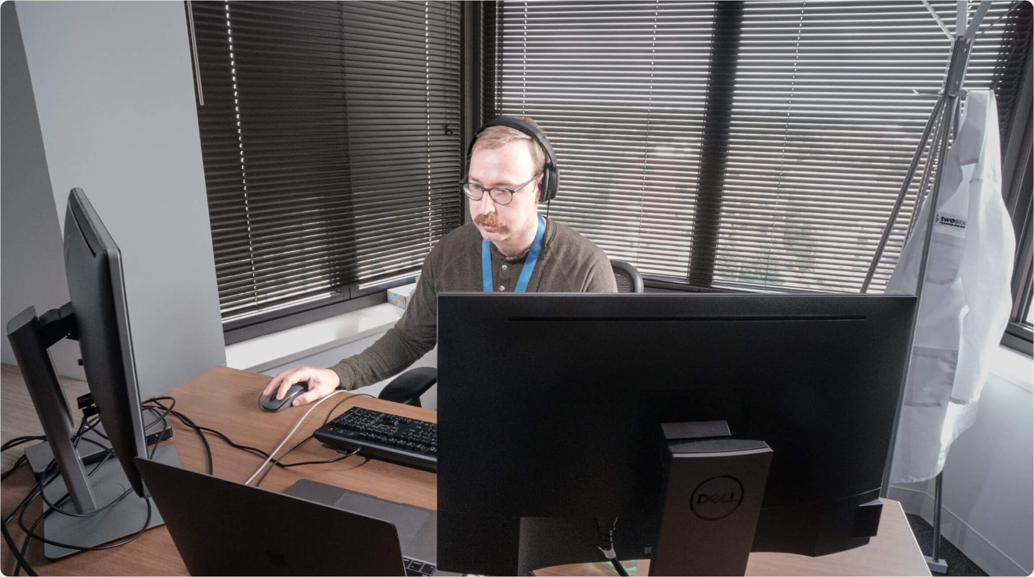 Two Six Tech team member working on a laptop and two monitors