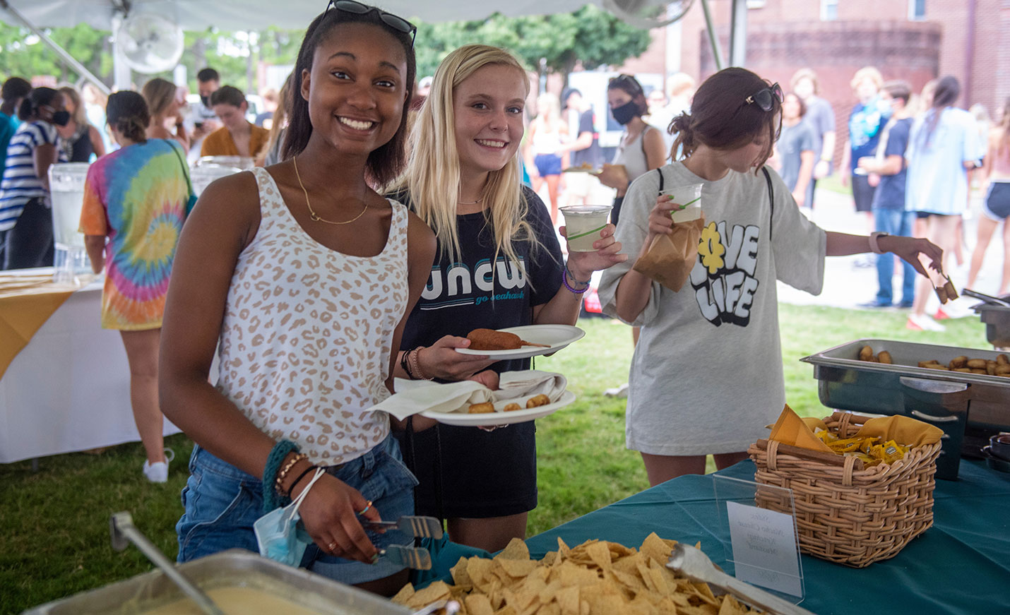 students smile as they get food on campus