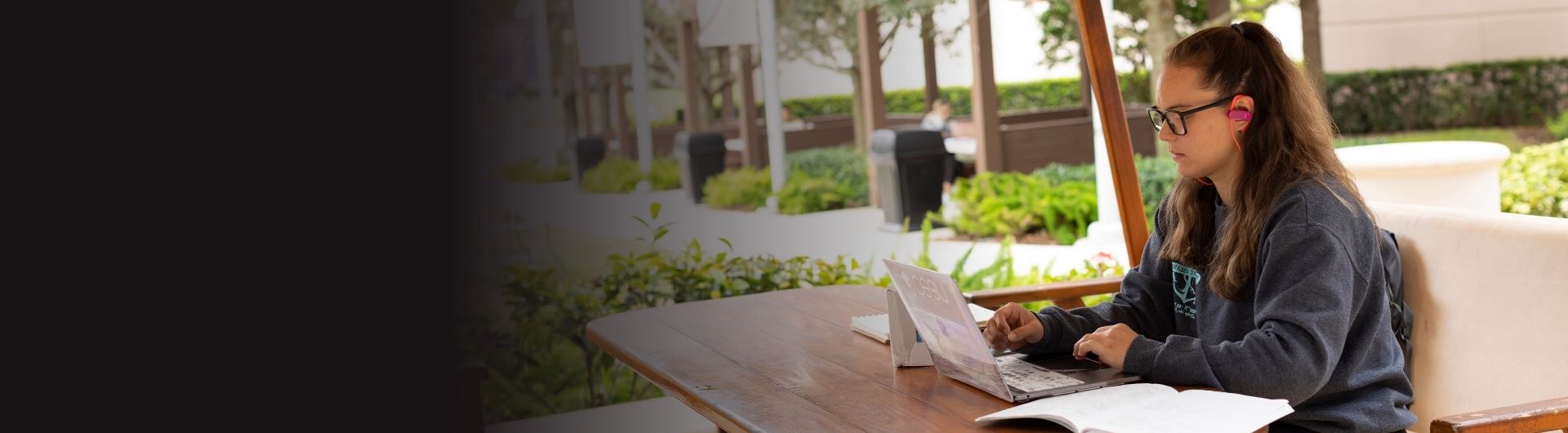 Student sitting on stairs reading an NSU financial aid brochure