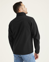 Back view of model wearing Black Chest Yoke Softshell Jacket.