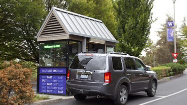 A car stops at a campus gatehouse