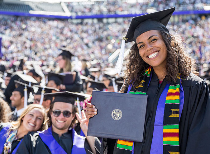 Student holds up diploma at UW Graduation Ceremony