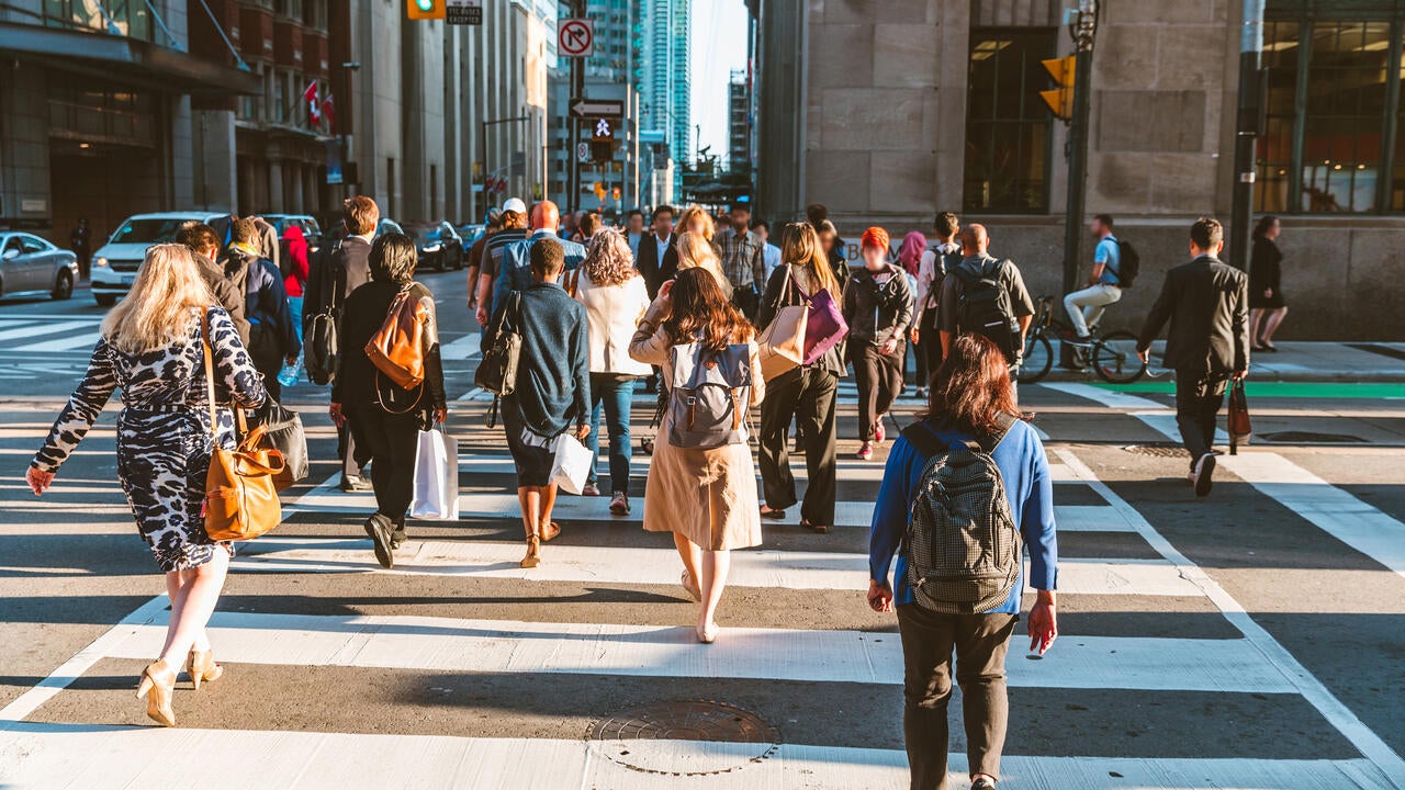 Crowd of unrecognizable people crossing street in Toronto, Canada at rush hour