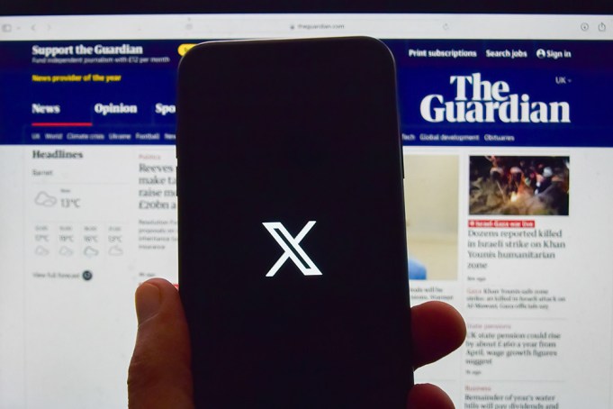 UNITED KINGDOM - 2024/09/10: In this photo illustration, an X, formerly Twitter logo seen displayed on a phone screen with The Guardian newspaper website on a laptop screen in the background. Broadcast regulator Ofcom's research shows 71% of the population have stated they use online platforms for news, while 70% watch TV news, as online news sources overtake TV for the first time. (Photo Illustration by Vuk Valcic/SOPA Images/LightRocket via Getty Images)