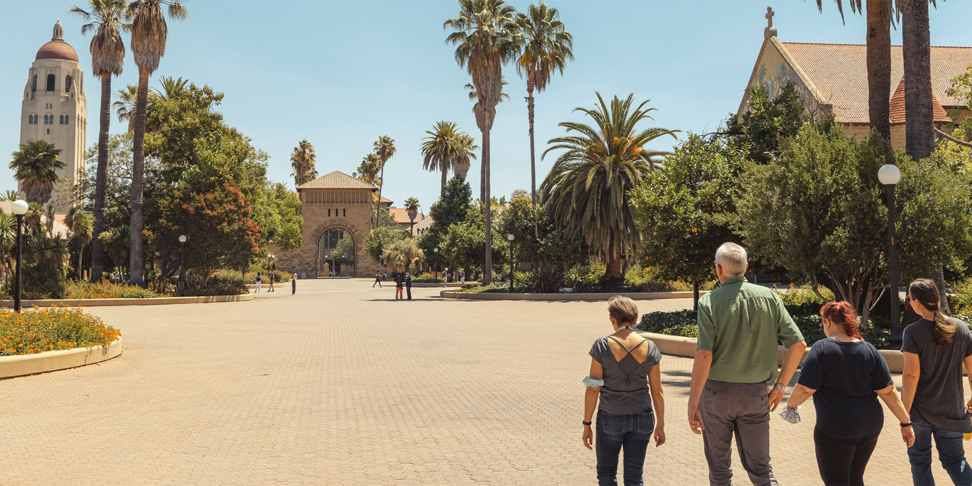 Family of four walks in the Main Quad