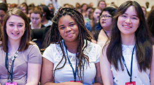 three students attending NCCWSL waiting for the next speaker to start.