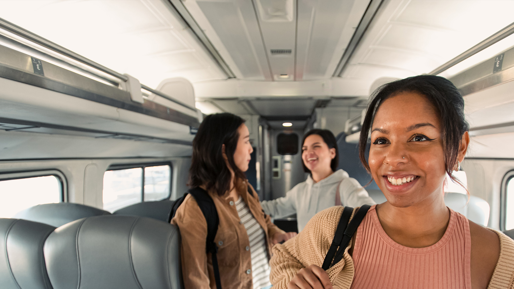 Étudiants souriants alors qu’ils trouvent un siège à bord.