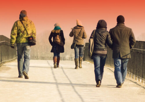 People walking on a bridge into the distance.