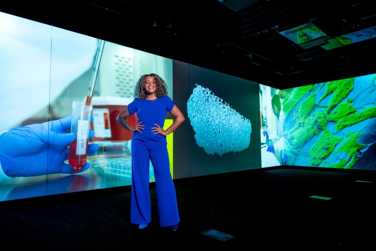 A person stands in front of a projected graphic