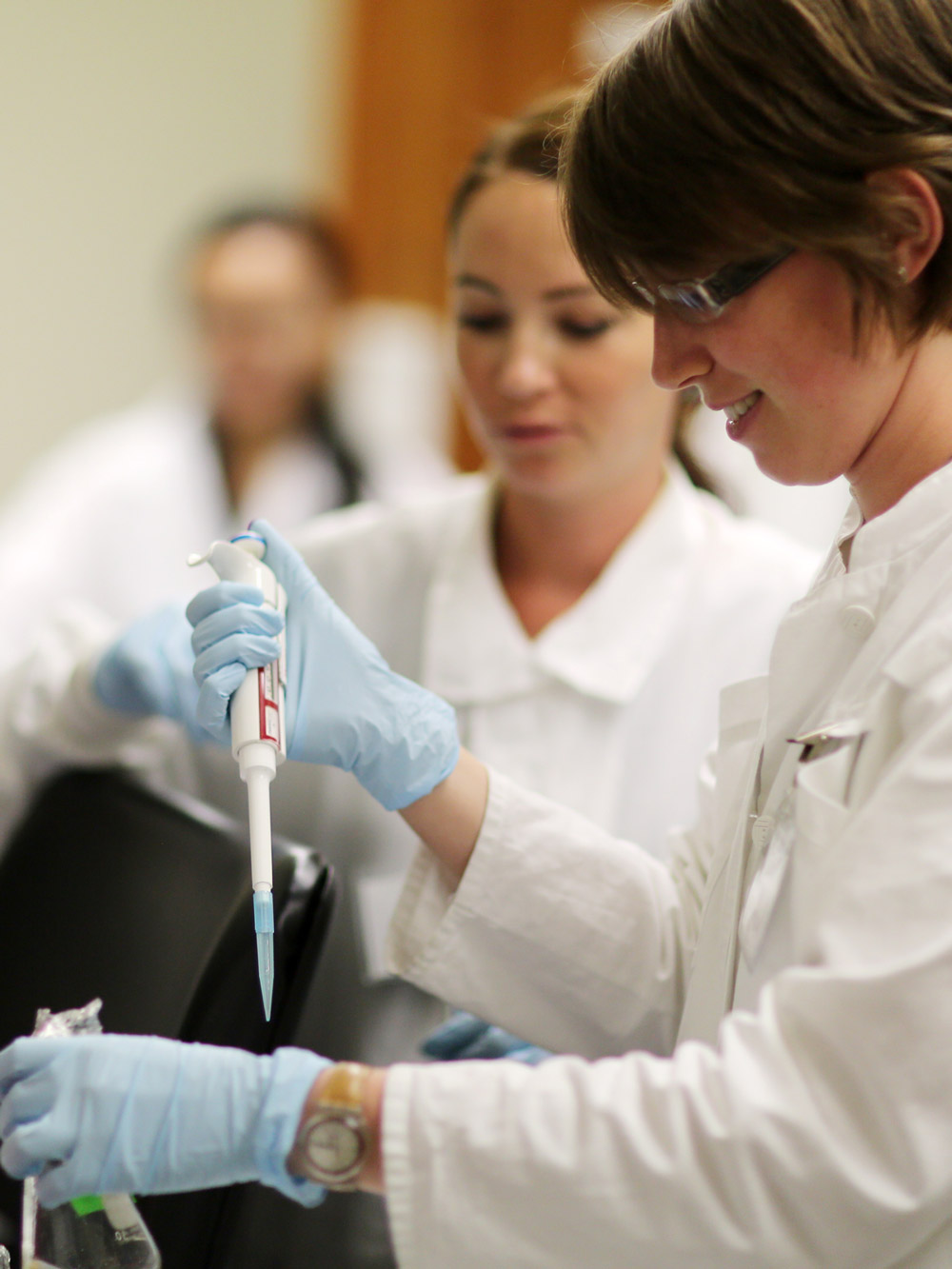 Two students using a pipet during an laboratory exercise.