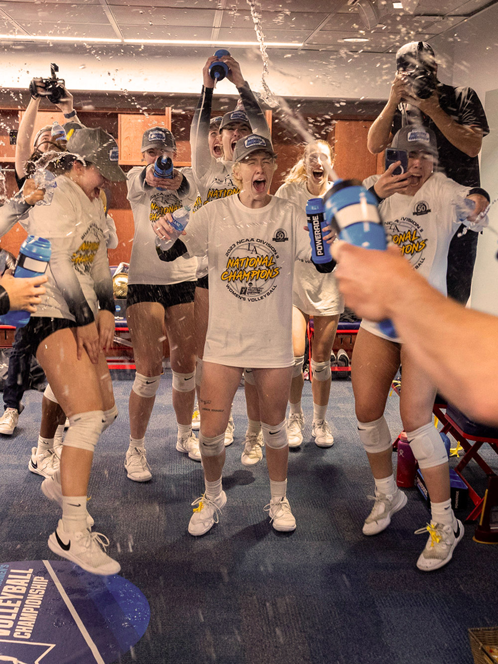 Womens volleyball team celebrating a win in the lockerroom.