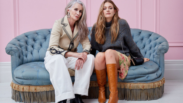 Two women sitting on a sofa. All the clothing, accessories and furniture in the photo were sourced Cancer Research UK charity shops.