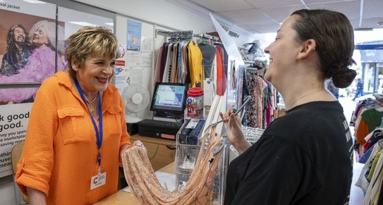 volunteer shop assistant smiling with customer