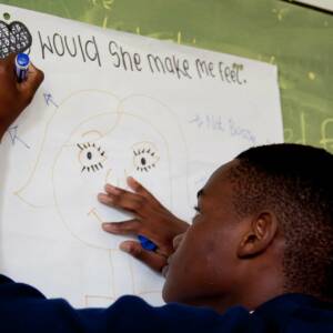 A young man making a drawing of a person