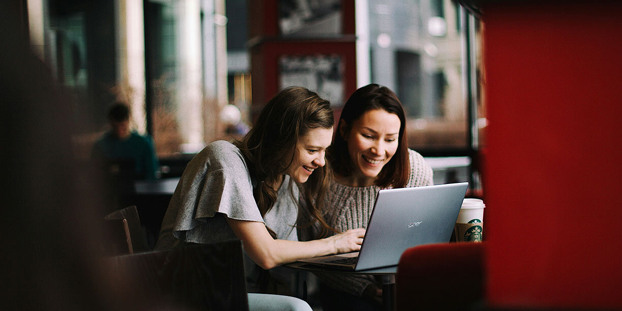 Two women designing a fundraising thermometer together on a computer