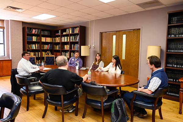 faculty senate members sit around a table