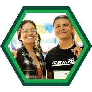 Two students smiling with Stingers Up hand gestures