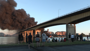 Crowds watch an industrial fire happening in Richmond, B.C., on June 20, 2024. 