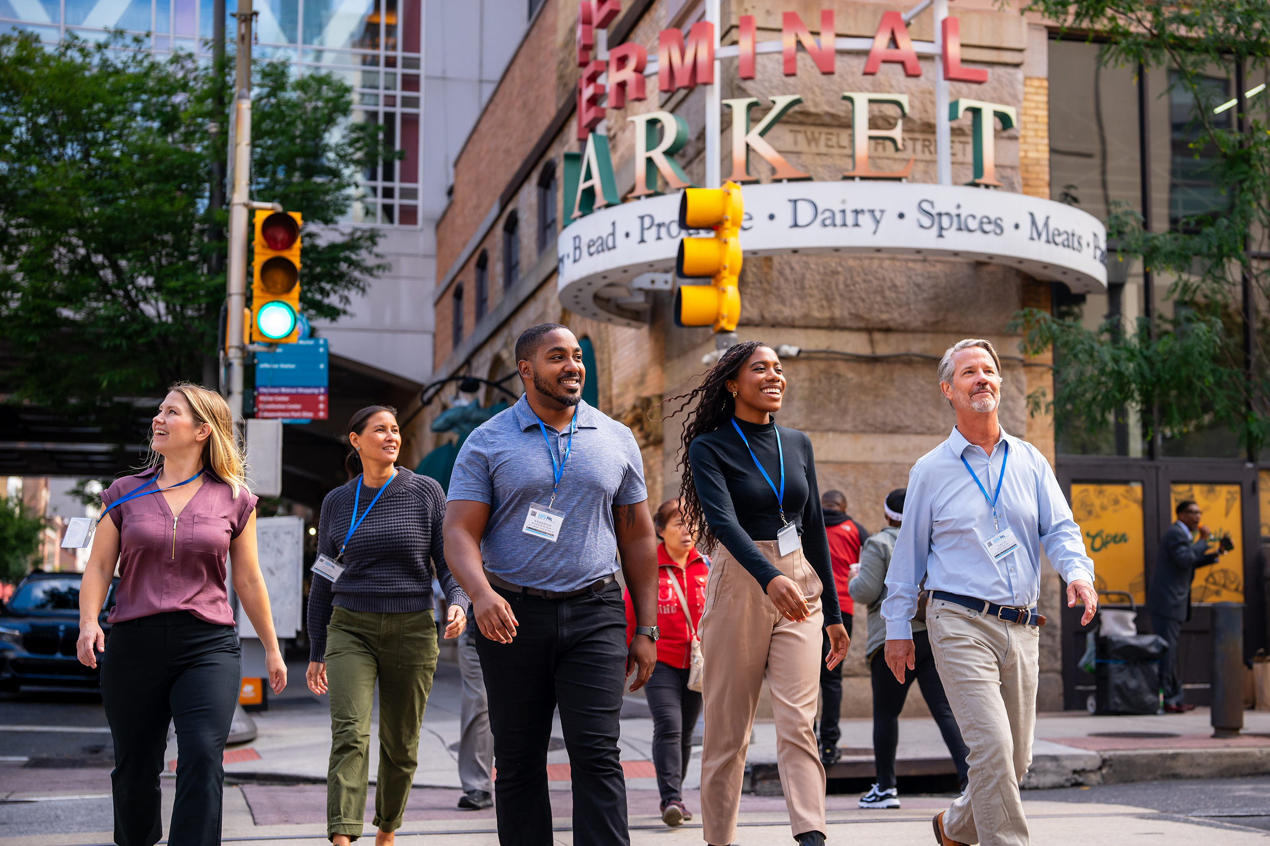 A group of badge holders walk past the Reading Terminal Market.