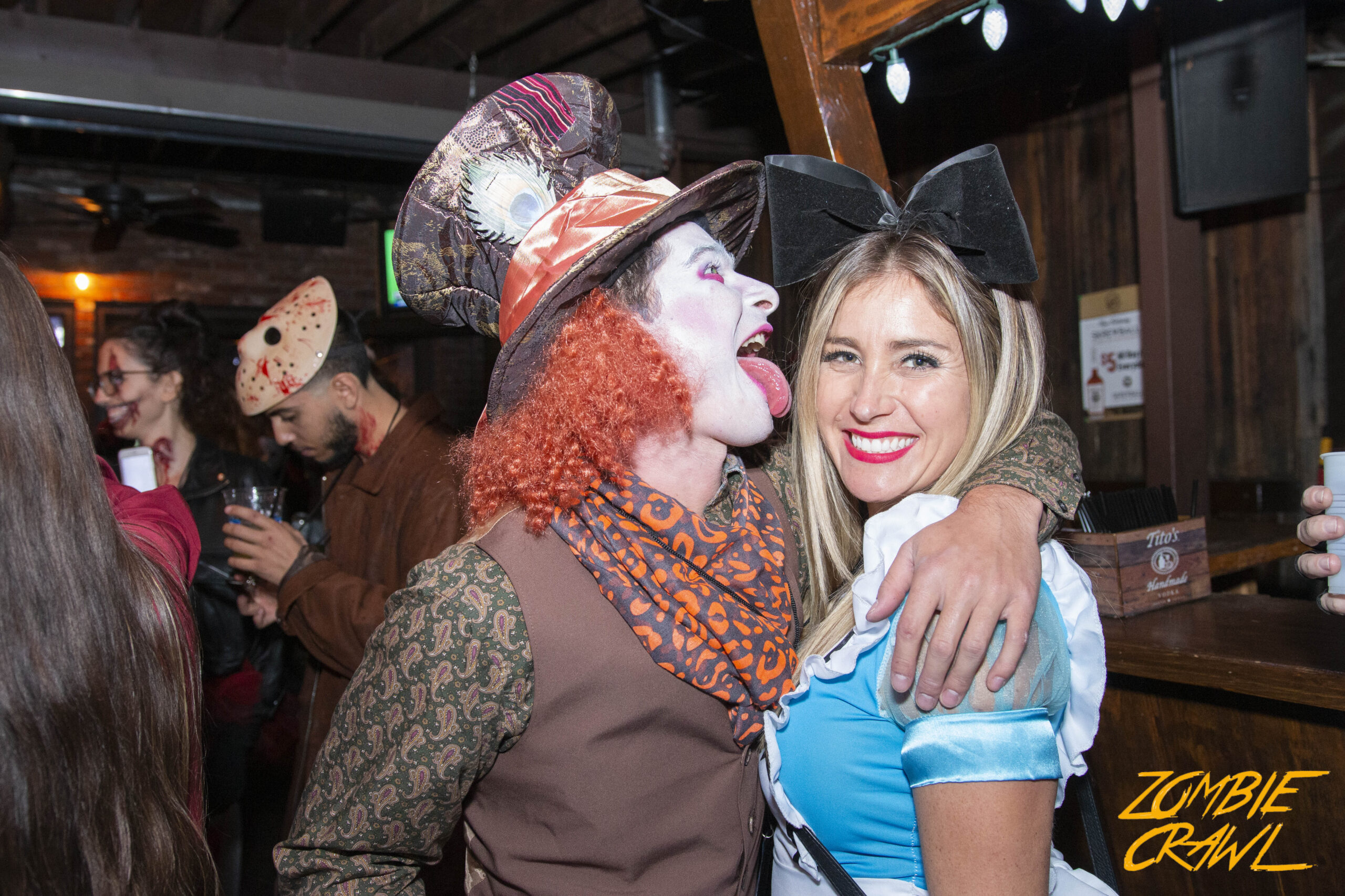 Event-goers dressed up as Alice In Wonderland and The Mad Hatter enjoy the Zombie Crawl