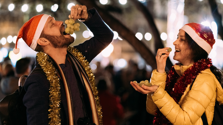 Two people eating grapes on New Year's Eve