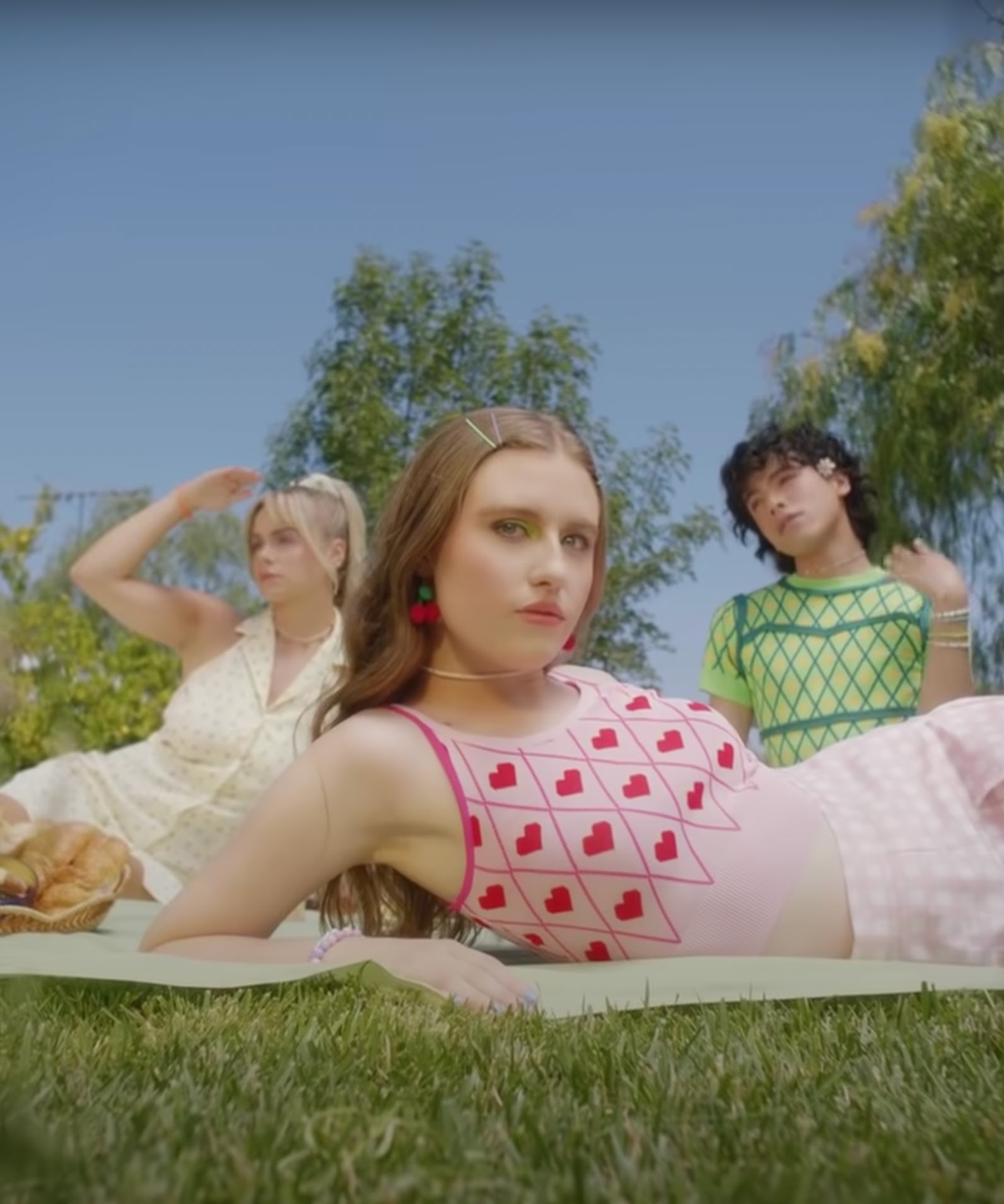 An image of three people in Cider clothing having a picnic.