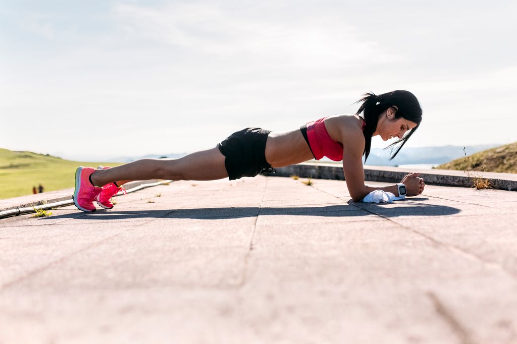 mujer haciendo planchas al aire libre