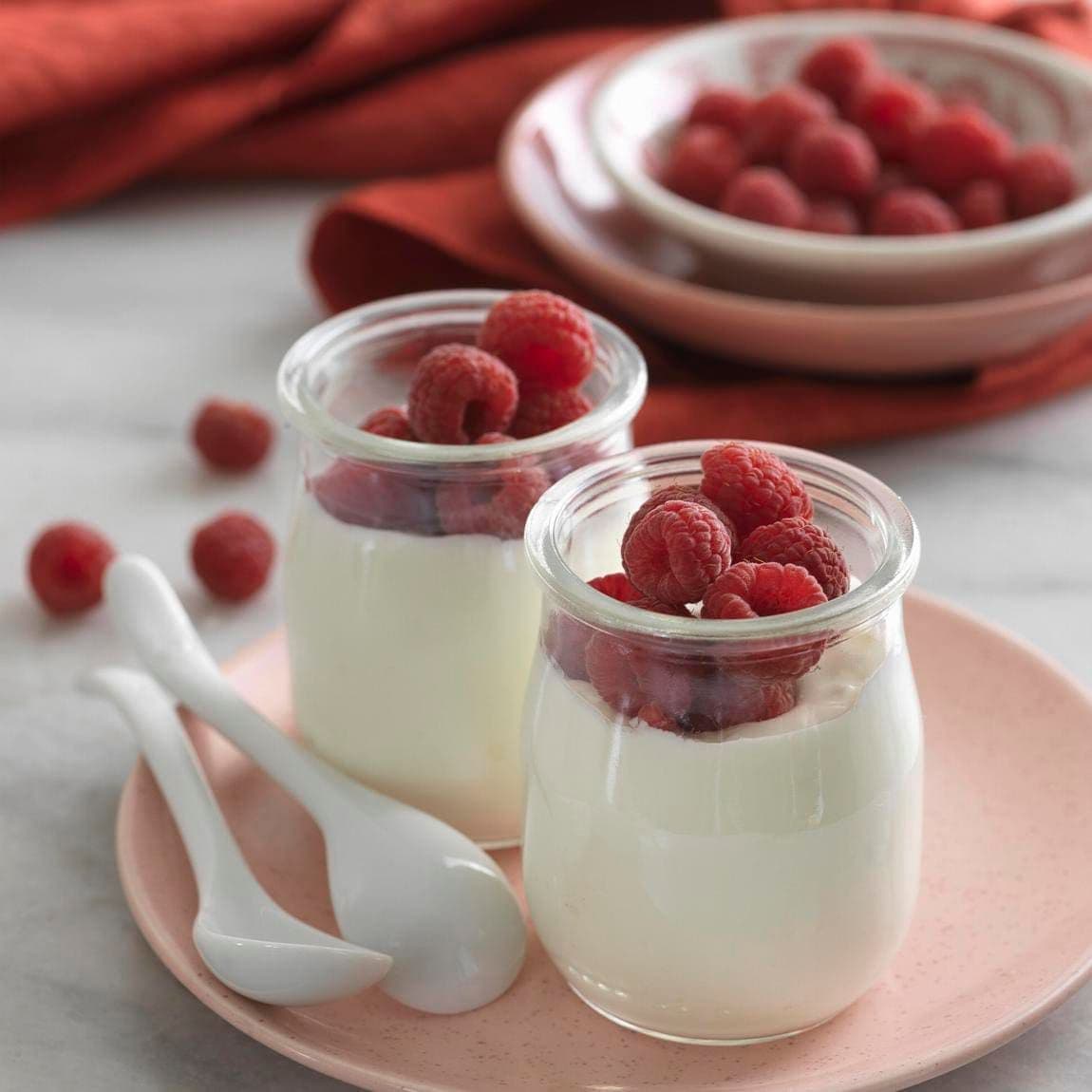 Two Glass Jars of Greek Yogurt with Raspberries