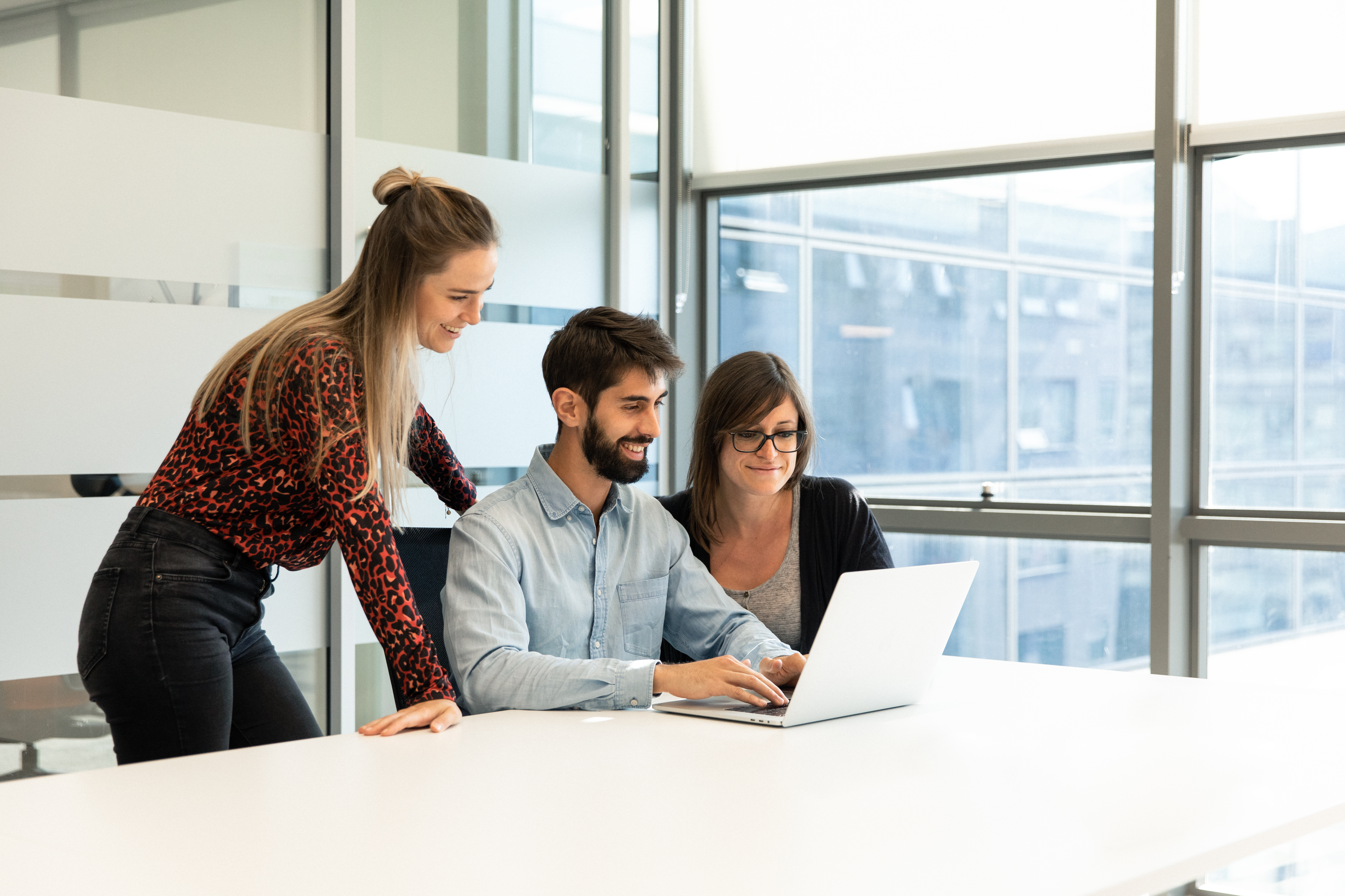 Pessoas trabalhando em sala de conferência. Use o CMS Hub para facilitar os processos de configuração de hospedagem do seu site. 