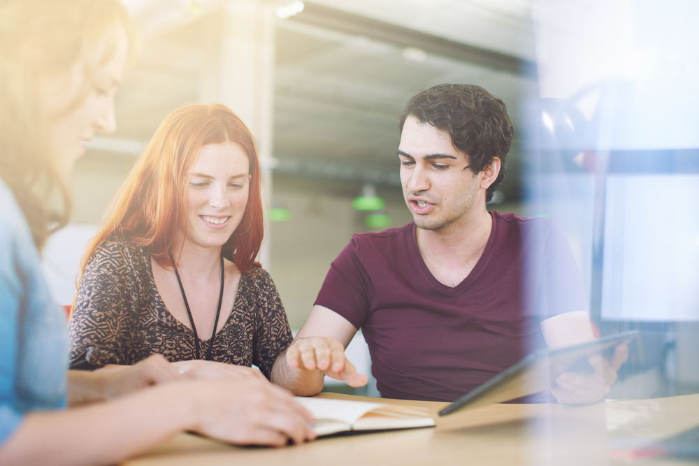 Grupo sem pose de funcionários criativos em um escritório de conceito aberto fazendo brainstorming de seu próximo projeto - fique tranquilo usando o CMS Hub da HubSpot