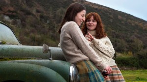 SAY NOTHING is a Hulu series produced by FX about The Troubles. Shown here are Hazel Doupe as Marian Price and Lola Petticrew as Dolours Price, leaning against a green car parked in front of a hill