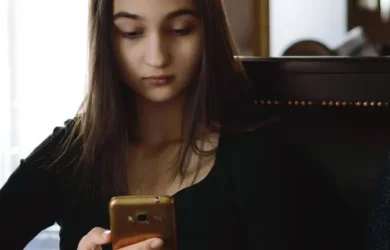 A teen girl looks at her smartphone.