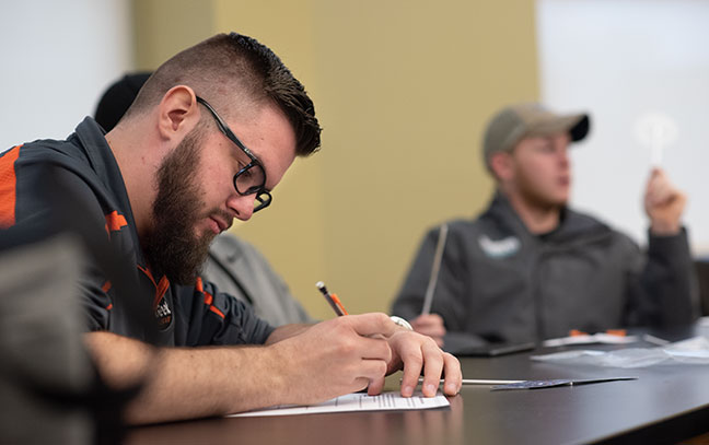 close up of a student taking notes in class