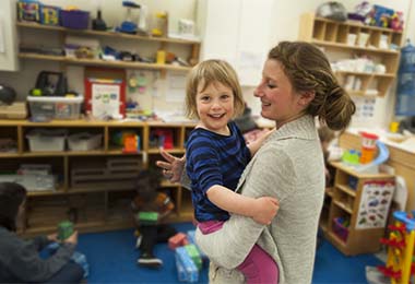 a woman smiling and holding a child