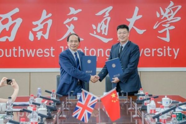 Professor Hai-Sui Yu with SWJTU President Xuedong Yan shaking hands and holding a strategic agreement.