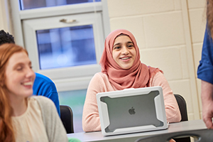 student in class with laptop