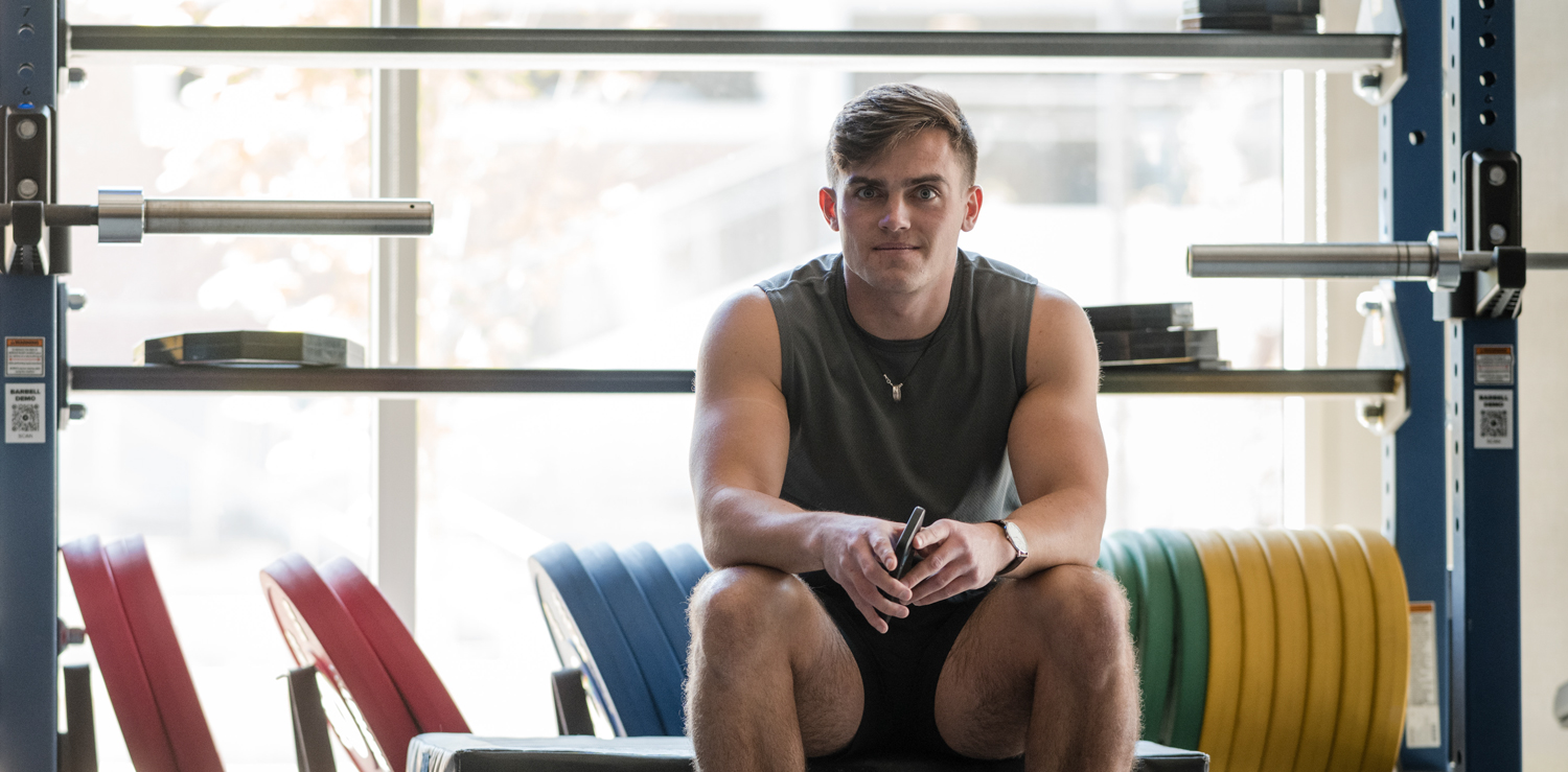 Student sitting in front of free weights