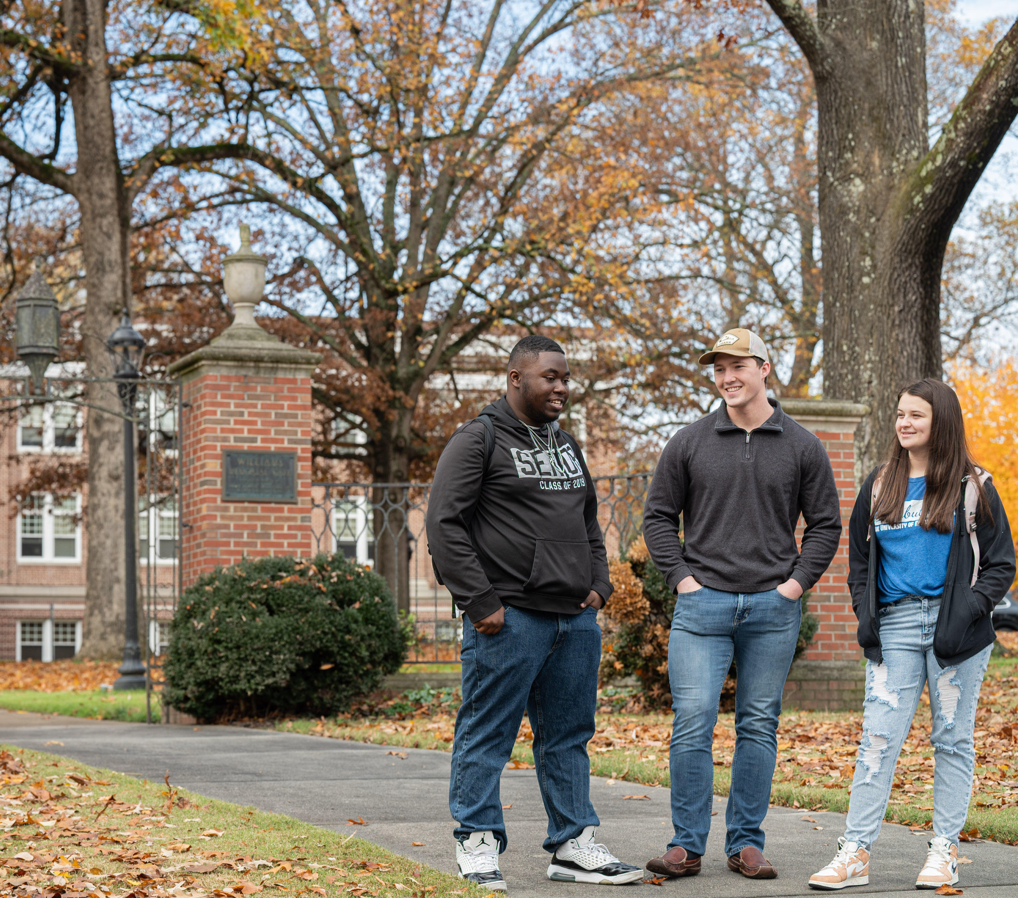 Three students walking around campus