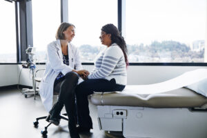 Smiling female doctor talking to woman in hospital