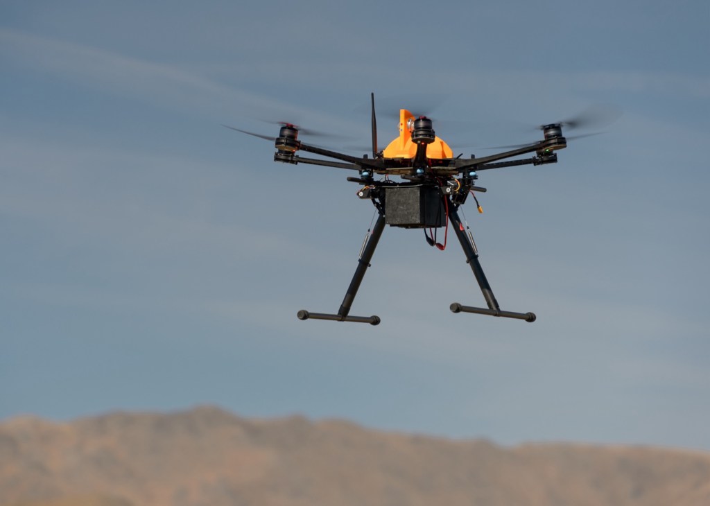 A black drone with an orange top in flight in Nevada.