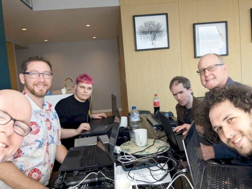 Quentin, Gerald, Sascha, Mick, James and Sean gathered around a table working