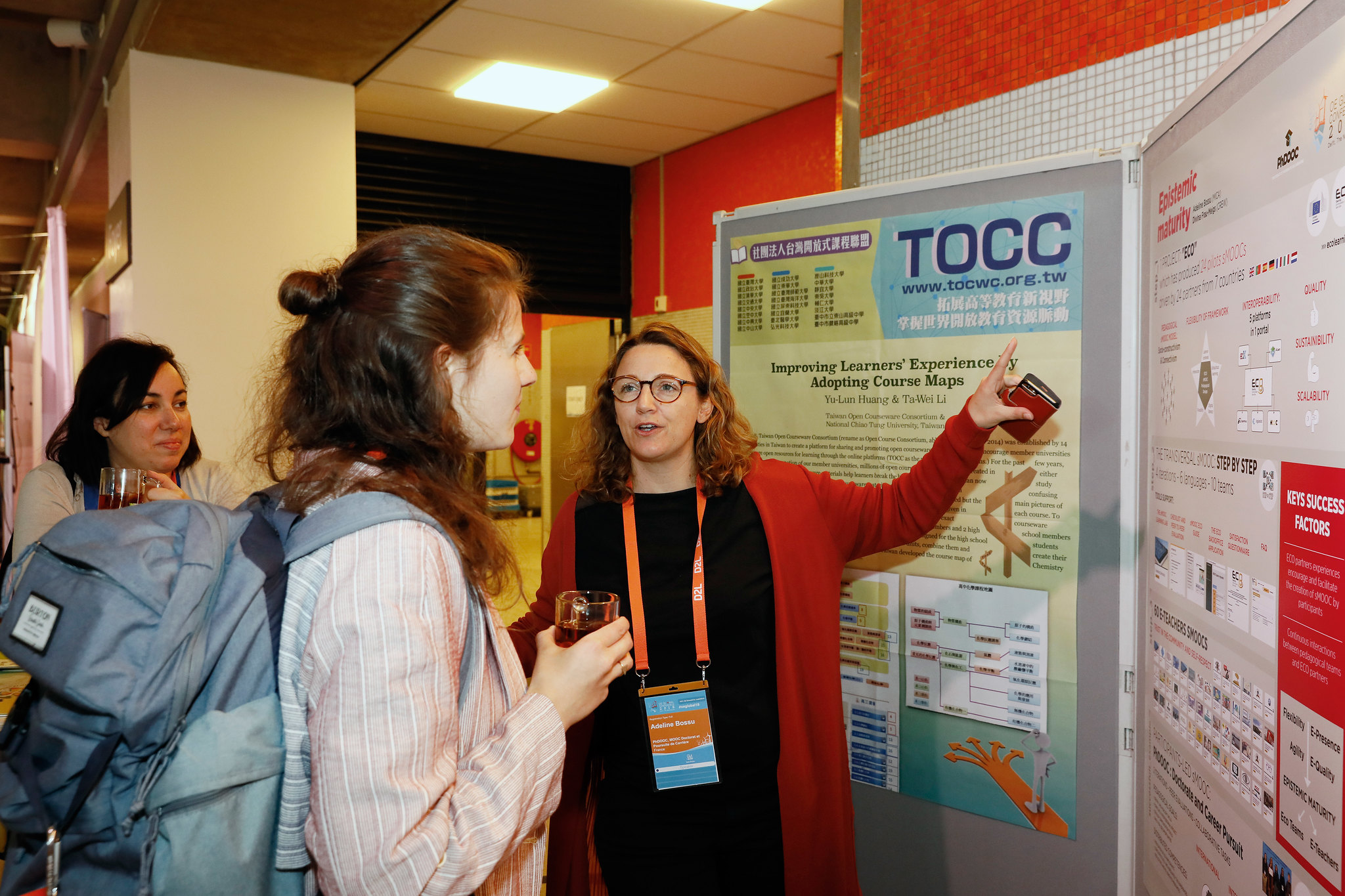 Woman explaining an academic poster to another woman.